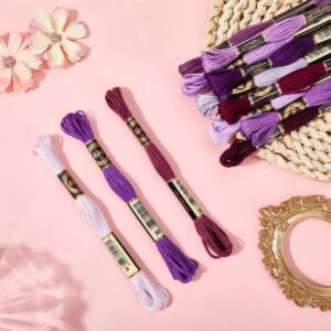 hilos mouliné lilas y púrpura para bordado sobre fondo rosa